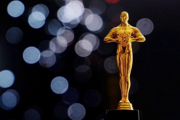 Hollywood Golden Oscar Academy award statue on black background with copy space. Success and victory concept.