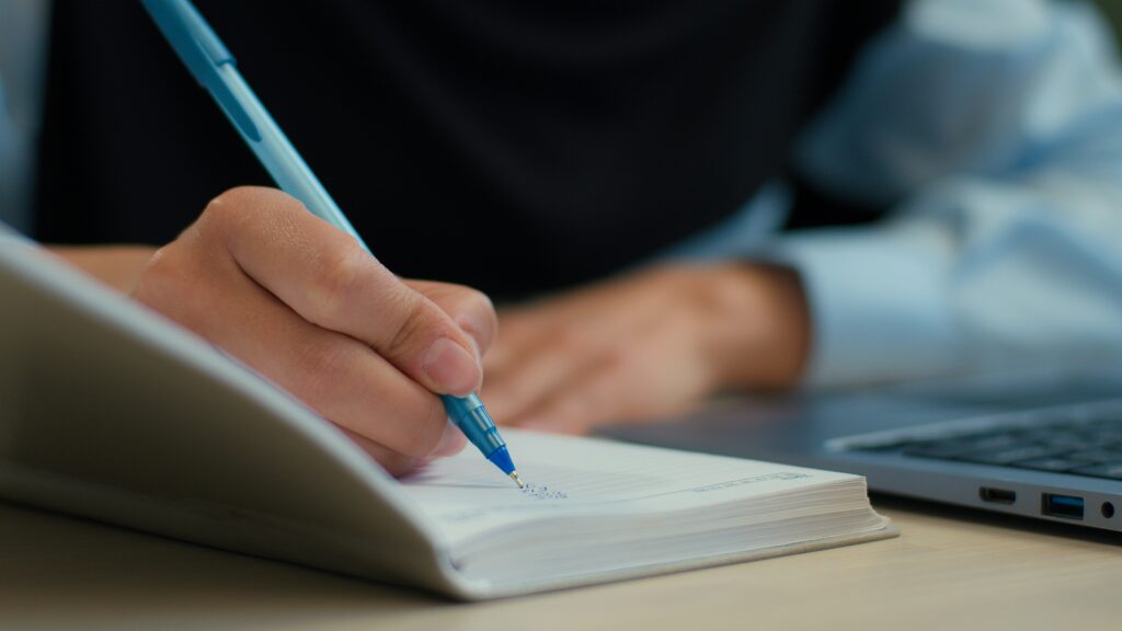 Cropped shot female hands student study use laptop write in notebook exam online education unknown muslim woman businesswoman girl employer worker writing notes business tasks schedule on table desk