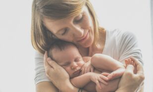 woman in white crew neck t-shirt carrying baby