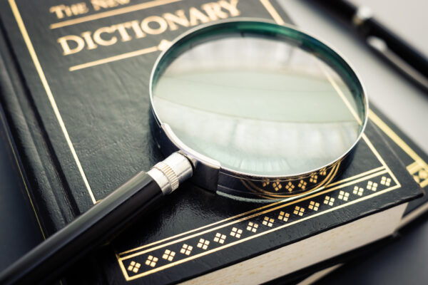 Closeup magnifying glass placed on the dictionary books on the table