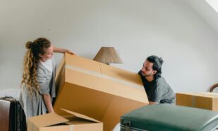 Man and woman carrying carton box