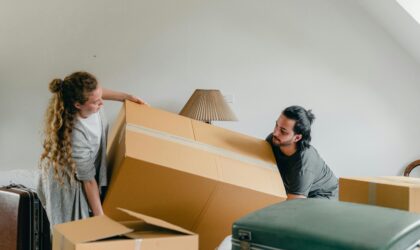 Man and woman carrying carton box