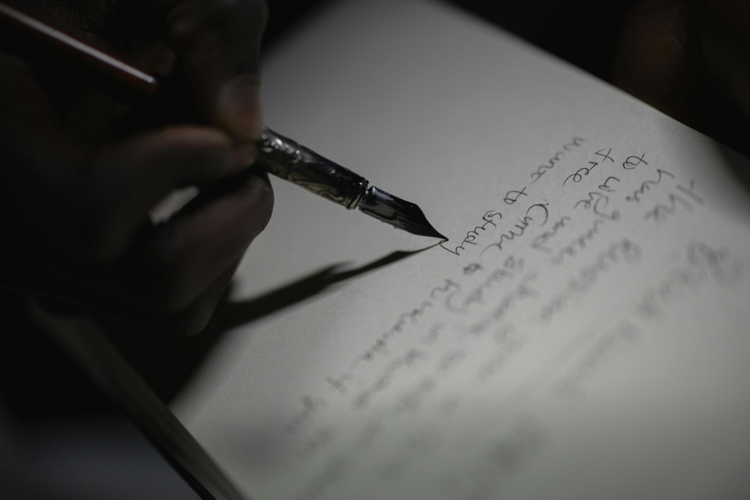 A Person Writing on the Paper Using Fountain Pen