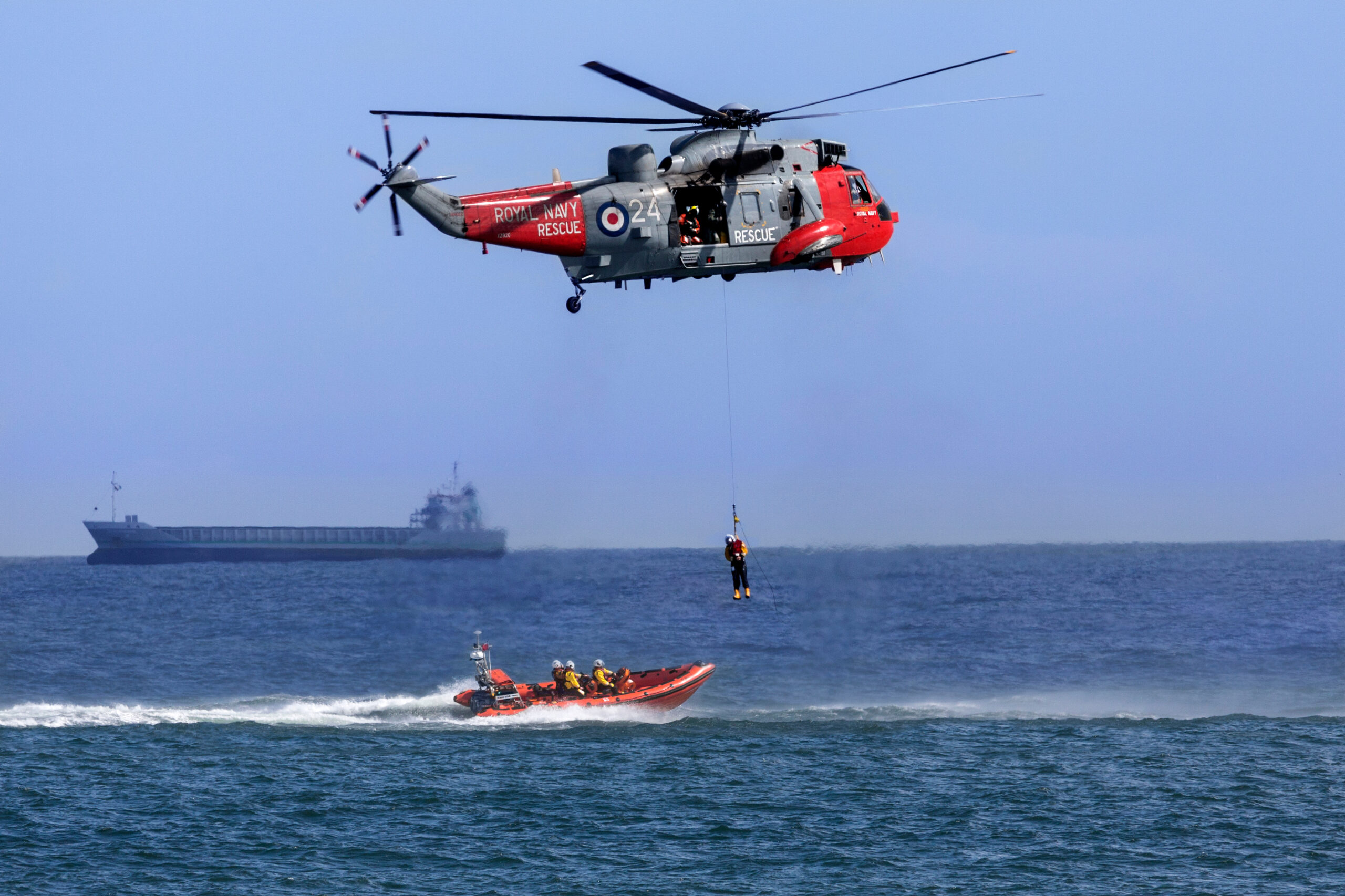 Royal Navy Sea King Search and Rescue helicopter lifting a casualty from a small boat in a busy shipping lane off the northeast coast of the United Kingdom.