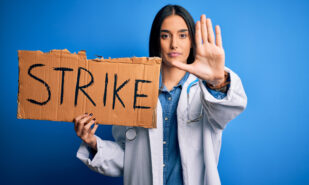 Young doctor woman wearing stethoscope holding cardboard banner protesting in strike with open hand doing stop sign with serious and confident expression, defense gesture