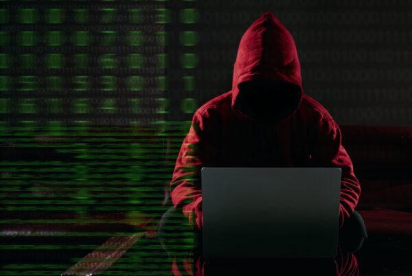 Hacking and malware concept. Hacker using laptop computer with binary code digital interface. Double exposure.