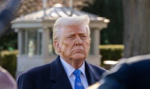 President Donald Trump stops to speak with media