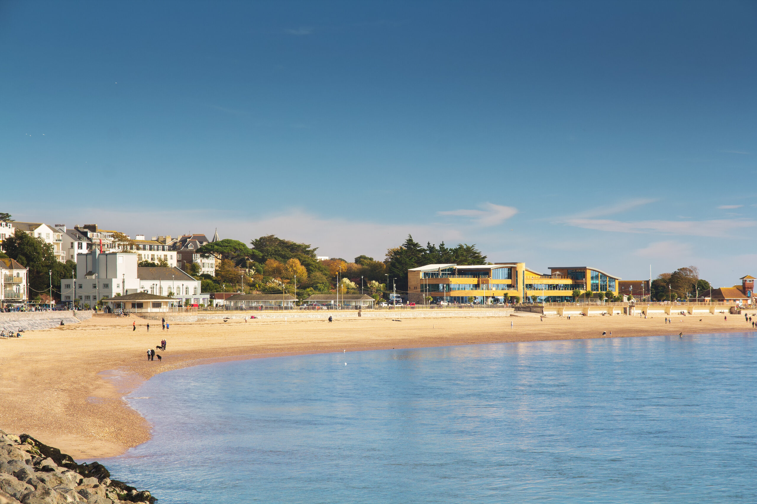 View of the coastal city of Exmouth. The city is in the mouth of the river Exe. On a beach in good weather people are walking - tourists and locals