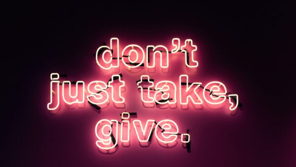 Neon sign saying "Don't just take, give."