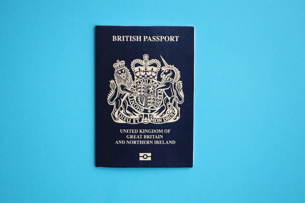 Blue British passport on blue background close up. Tourism and citizenship concept
