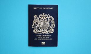 Blue British passport on blue background close up. Tourism and citizenship concept