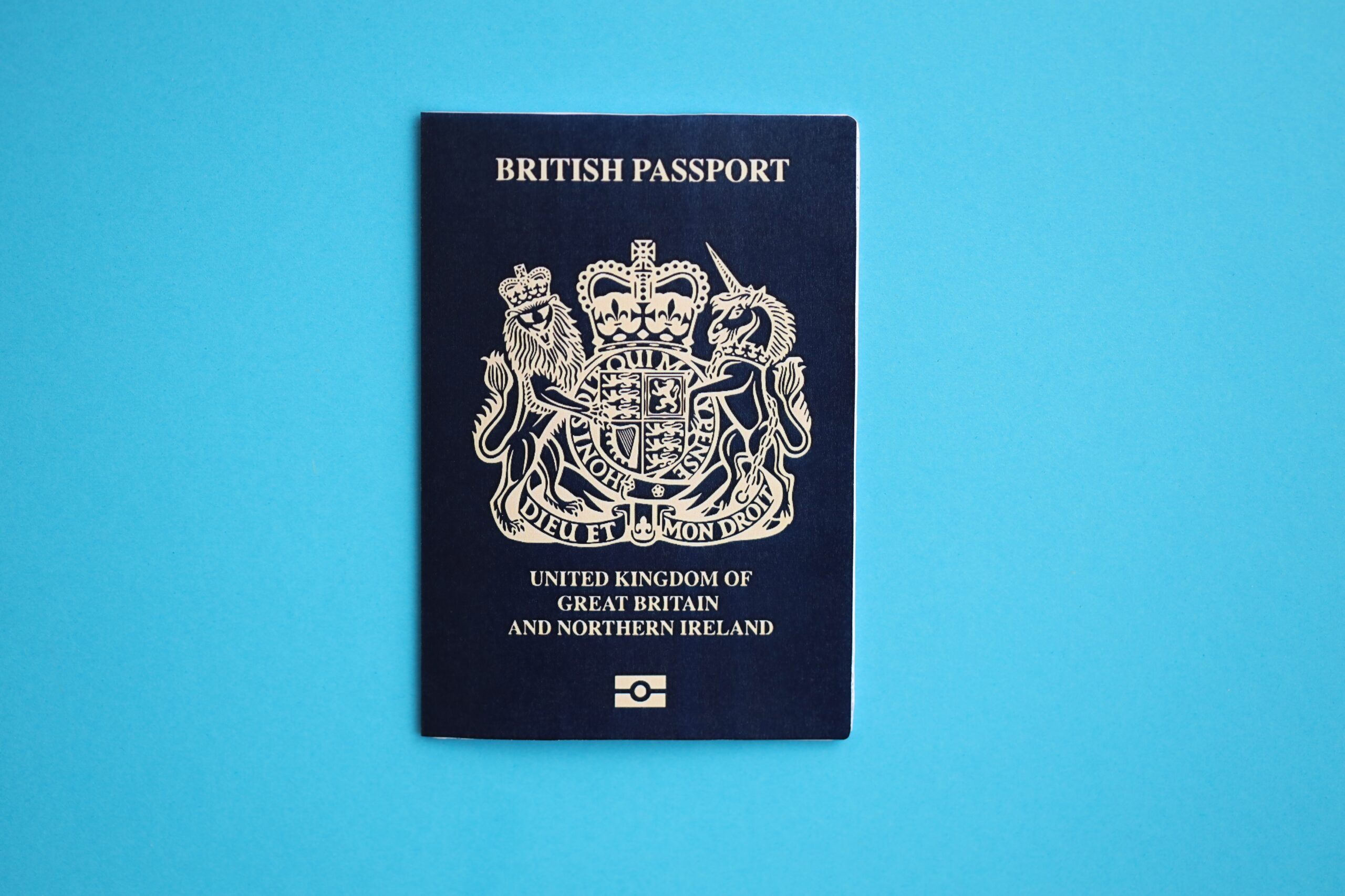 Blue British passport on blue background close up. Tourism and citizenship concept