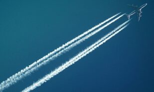 A plane in the sky with two white trails behind it
