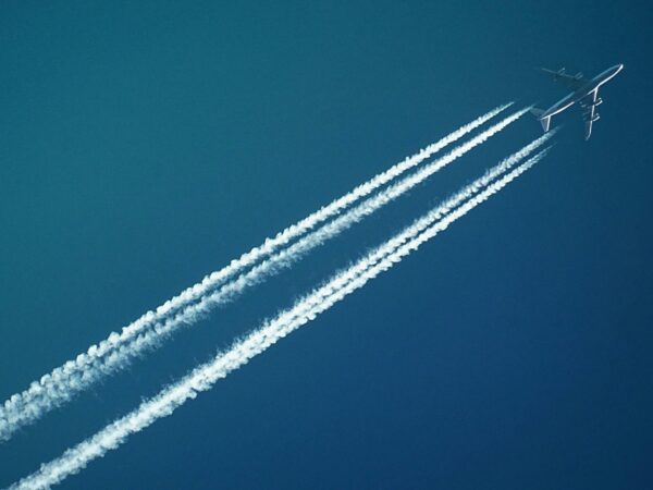 A plane in the sky with two white trails behind it