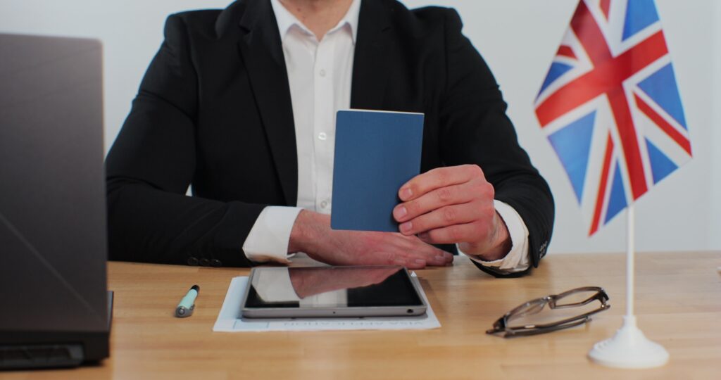British embassy man officer showing passport immigrant, work visa, citizenship. Visa Application online form immigration concept. Visa approval.