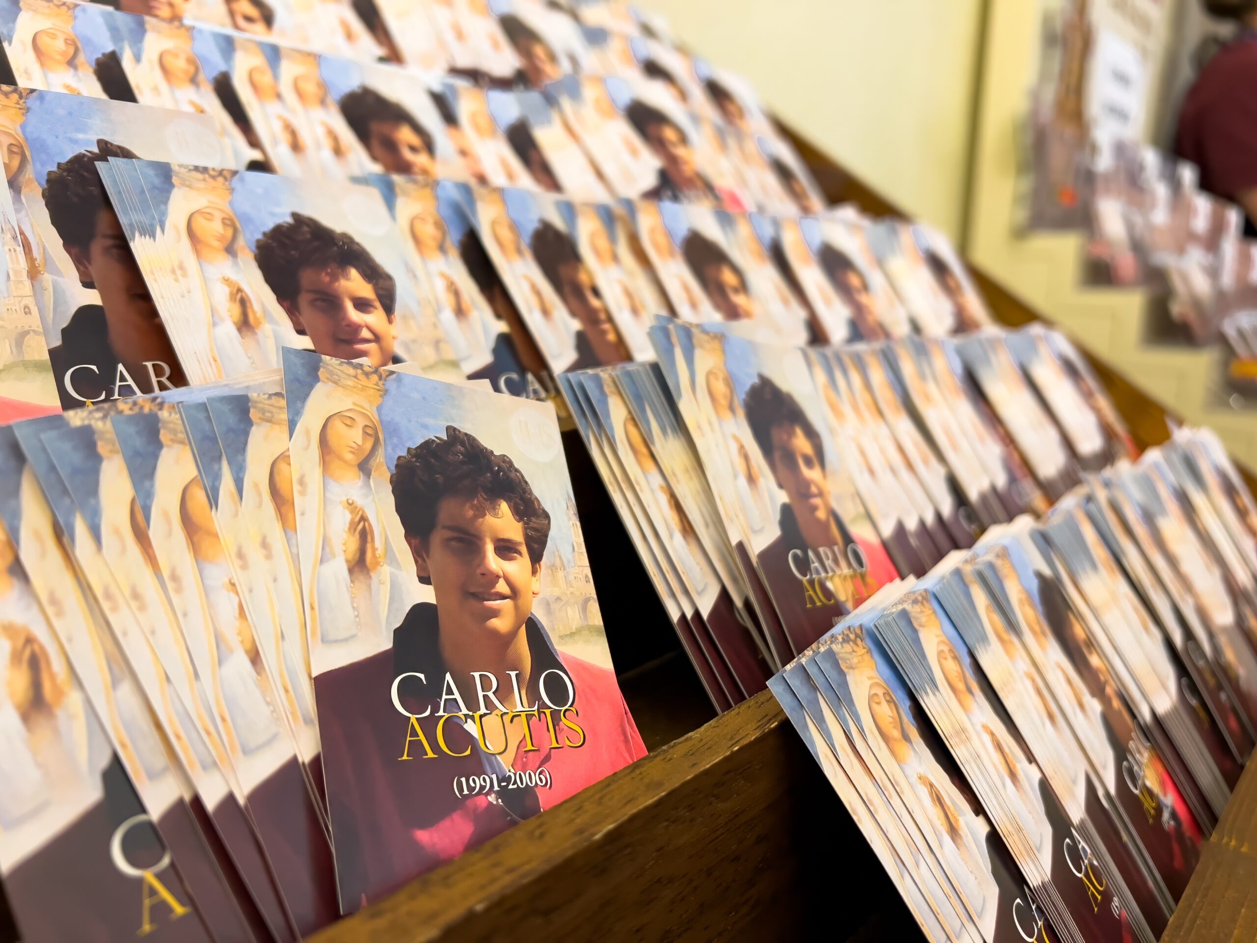 Little posters of Carlo Acutis with the prayer to him on the back side