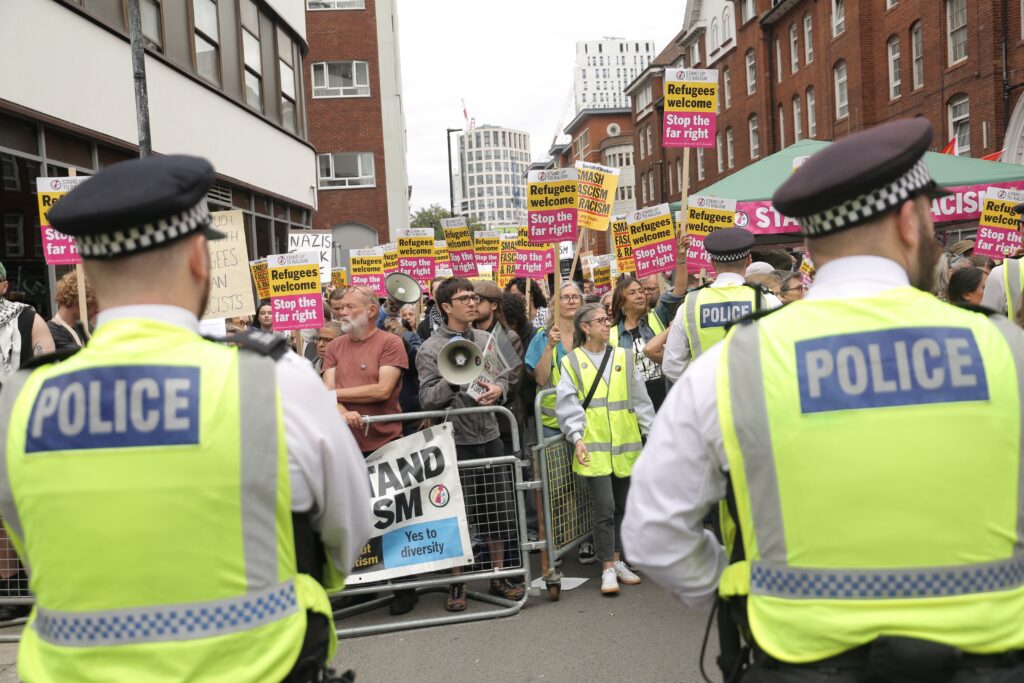 Pro- and anti-migrant protesters gather outside in London, where asylum seekers are housed. Police separate both groups as tensions rise.