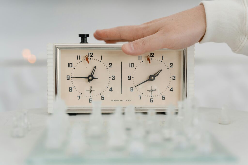 a hand atop of a chess double clock