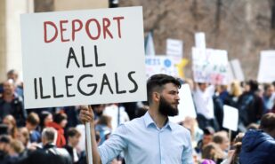 Angry man hold deport all illegals banner. Immigration crisis protest. Crowd wave placard. Stop no immigrants deportation. Anti migration demonstration. Guy against migrants. Refugee march city street