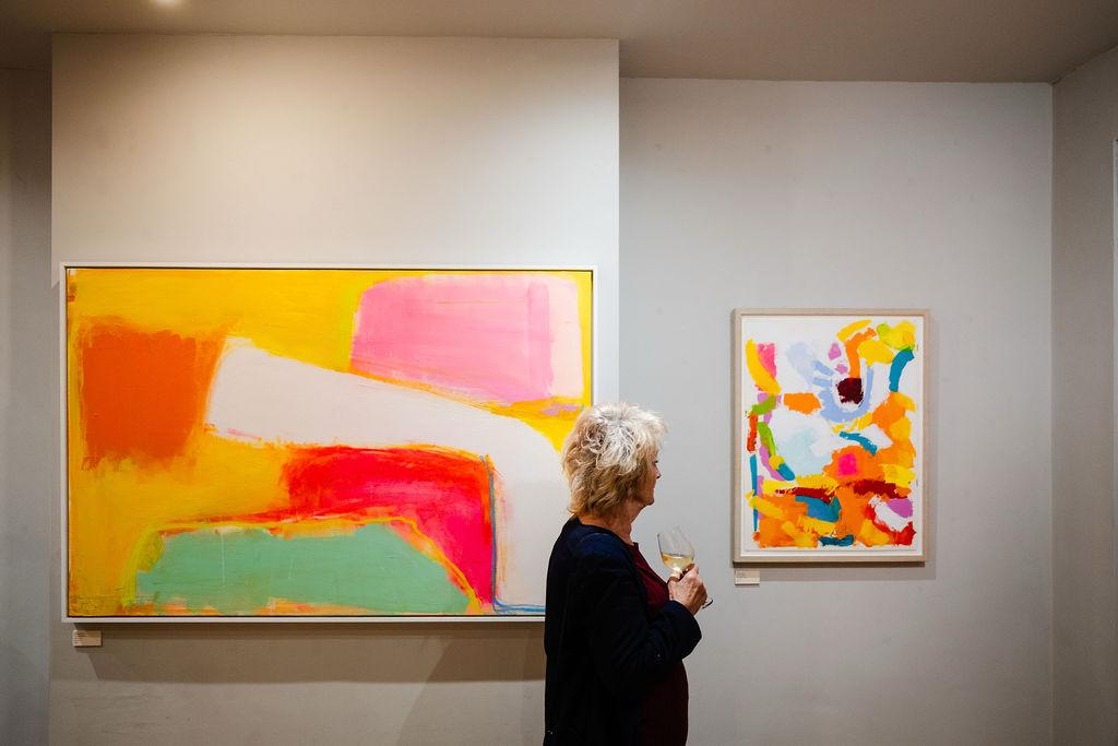 A woman looking at Sophie Lévy Burton's paintings. Photo by Marzena Pogorzaly