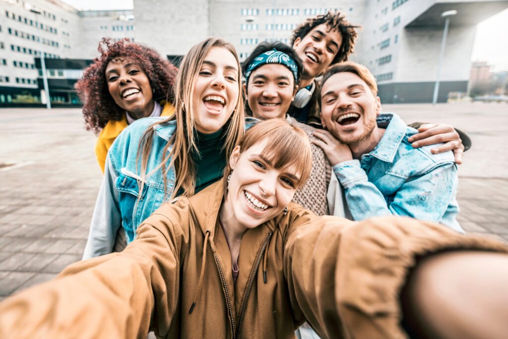 Group multiracial friends taking selfie picture with mobile smar