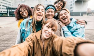 Group multiracial friends taking selfie picture with mobile smar