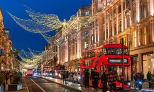 London, England, UK - November 23, 2022: Street view of Traditional buildings in London illuminated by Christmas angel decorations at dusk