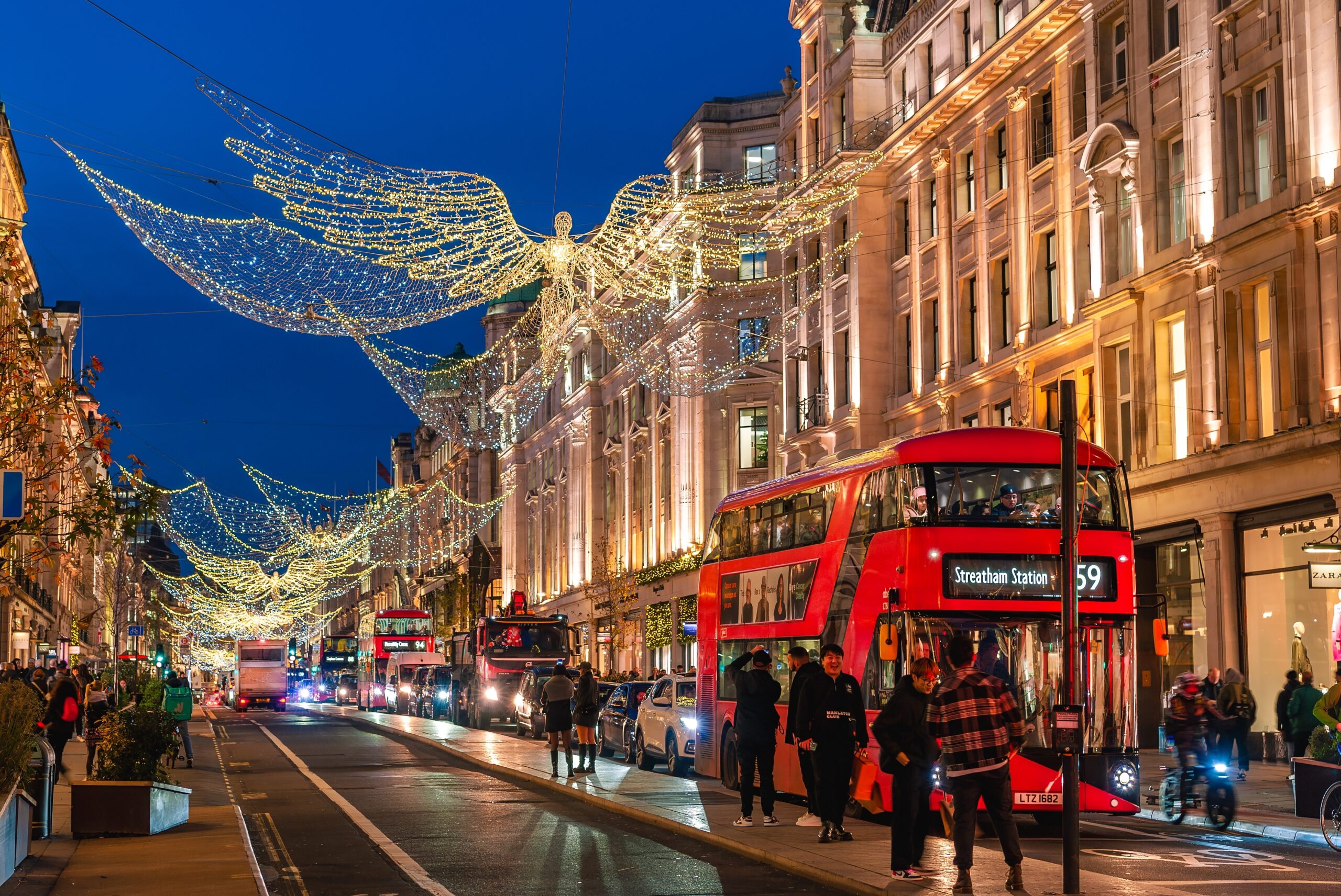London, England, UK - November 23, 2022: Street view of Traditional buildings in London illuminated by Christmas angel decorations at dusk