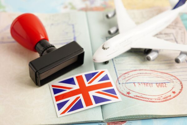 United Kingdom UK Visa flag and passport with airplane for travel.
