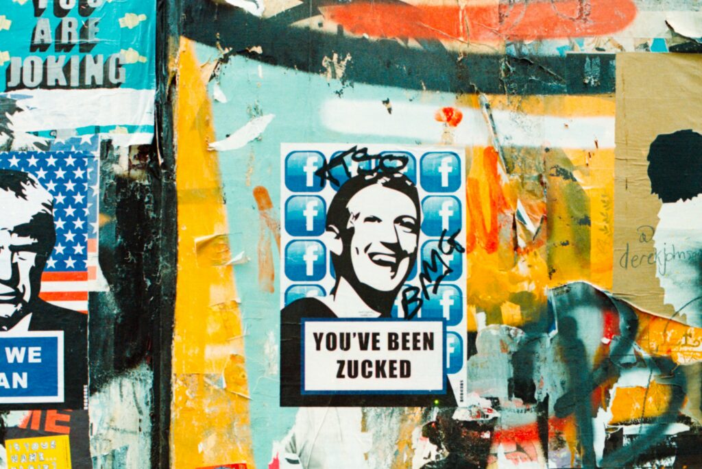 Stickers on a building wall, sticker sayink You've been zacked under drawn portrait of Mark Zuckerberg