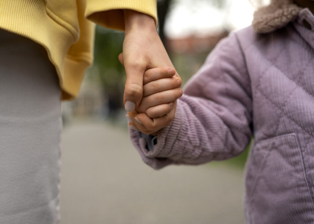 mother and child holding hands close up
