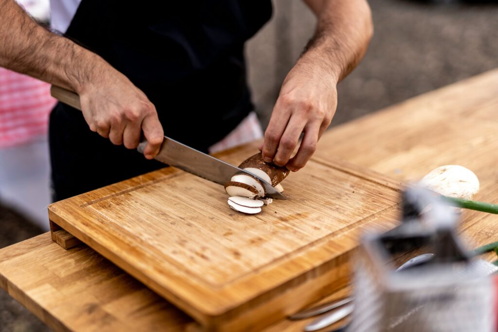 a man cutting mushrooms on a cutting board