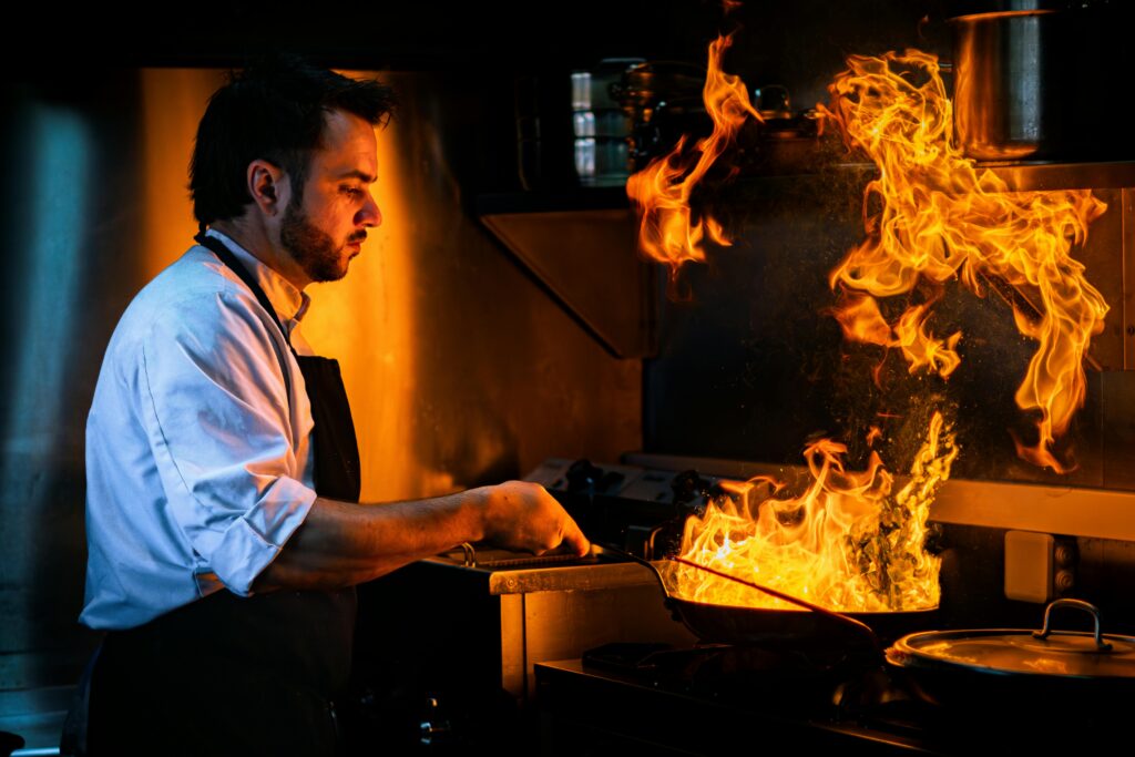 Chef Creating Fiery Culinary Art in Modern Kitchen