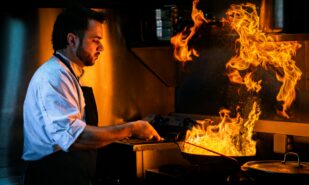 Chef Creating Fiery Culinary Art in Modern Kitchen
