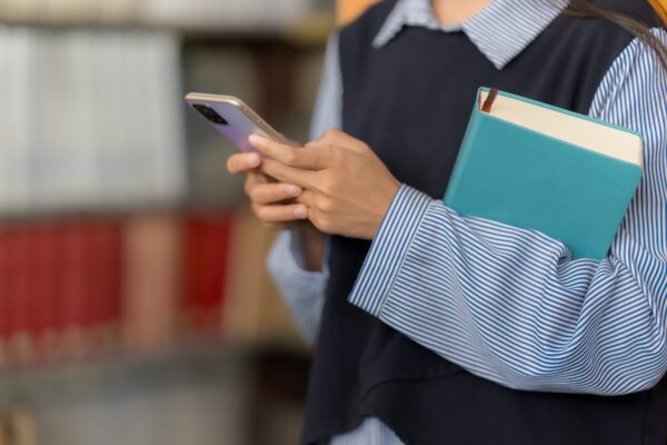 Asian woman chats with AI on mobile to enhance knowledge