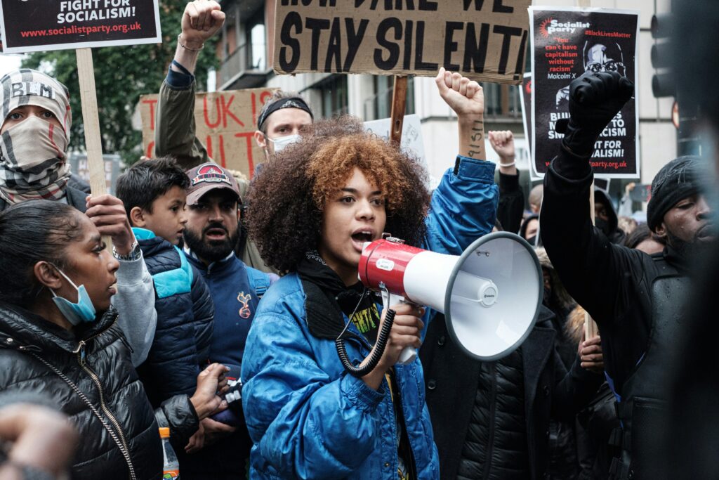woman in blue jacket protesting with megaphone
