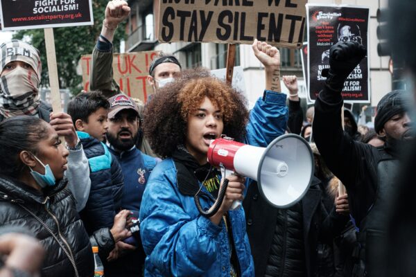 woman in blue jacket protesting with megaphone