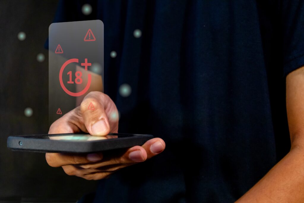 Man holding a smart phone with restricted content for mature audience on virtual screen