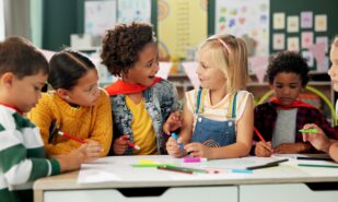 Happy children, drawing and coloring with classmates in kindergarten for fun activity in classroom. Group of young elementary kids sketching colorful paper, poster or sign for learning or development
