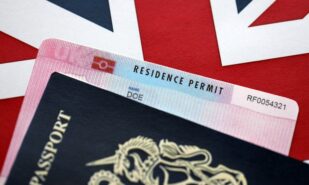 Residence Permit BRP card and British Passport of United Kingdom on Union Jack flag close up