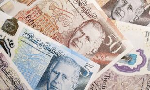 KYIV, UKRAINE - SEPTEMBER 17, 2025 Big pile of British pound money bills on table close up