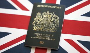 Black British passport on UK Union Jack flag close up
